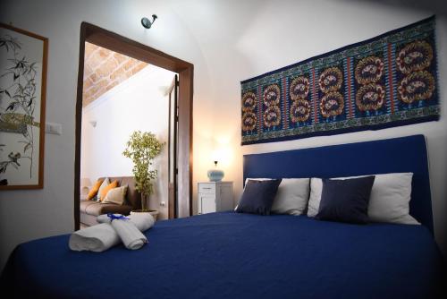 a bedroom with a blue bed with pillows at L'Arco in Terrasini