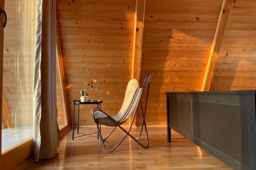 a chair in a room with a wooden wall at Petrovaradin Chalet in Novi Sad
