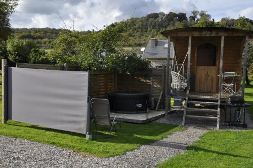 een tuinhuisje en een whiteboard in een tuin bij La Maison du Bonheur Roulotte in Saint-Ouen-sous-Bailly