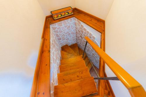 a wooden staircase in a house with a suitcase on it at ToviMar Apartments in Taormina