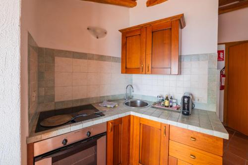 a kitchen with wooden cabinets and a sink at ToviMar Apartments in Taormina