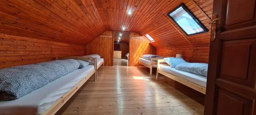 a room with three beds in a wooden cabin at Dukla Ranč in Nižný Komárnik