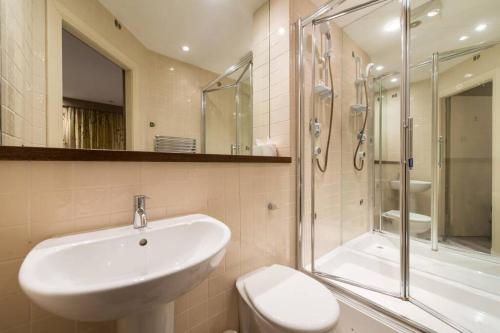 uma casa de banho com um lavatório, um chuveiro e um WC. em Royal Mile & Arthur's Seat Apt with Private Parking em Edinburgo