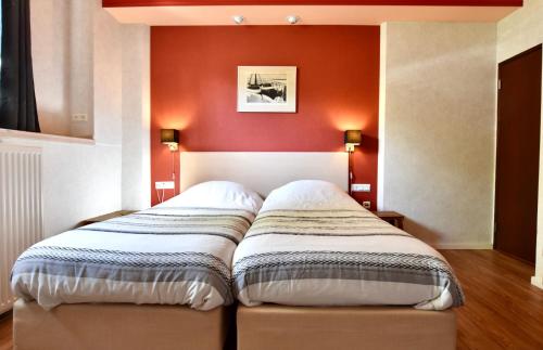 a bed in a room with a red wall at Resort De Vlasschure in Wissenkerke