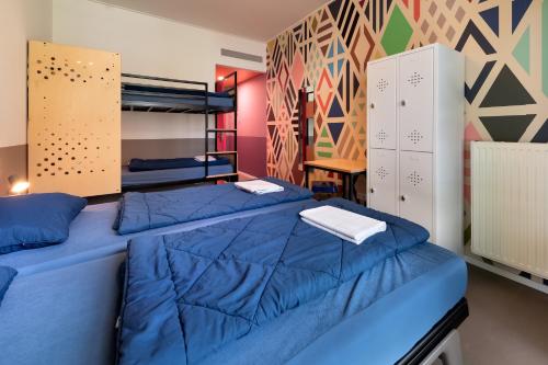 a bedroom with two beds with blue sheets at Stayokay Hostel Maastricht in Maastricht