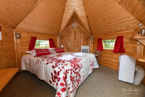 Le BoupèreにあるDomaine de La Courillèreの木造キャビン内のベッド1台が備わるベッドルーム1室を利用します。