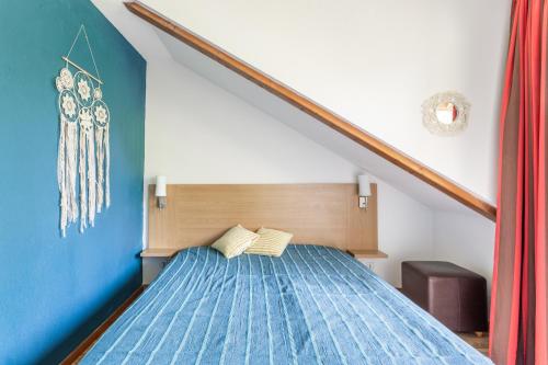 Schlafzimmer mit einem Bett mit blauer Decke in der Unterkunft L'Oural in Les Orres
