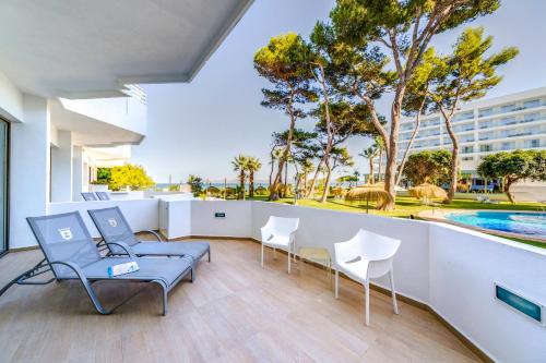 a balcony with chairs and a swimming pool at Playa Esperanza Resort Affiliated by Meliá in Playa de Muro