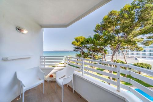 a balcony with white chairs and a view of the ocean at Playa Esperanza Resort Affiliated by Meliá in Playa de Muro