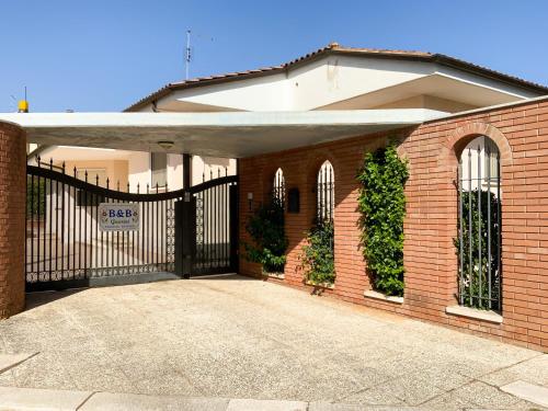 a brick house with a black wrought iron gate at B&B Guarini in Casamassima