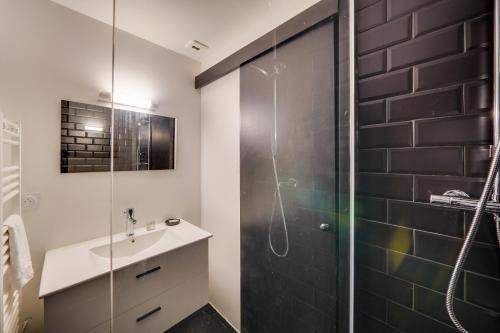 La salle de bains est pourvue d'un lavabo et d'une douche en verre. dans l'établissement Nice apartment for 2 in historical center, à Bordeaux