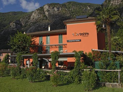 ein orangefarbenes Gebäude mit einem Berg im Hintergrund in der Unterkunft Ristorante Charme Hotel Tre Terre in Ponte Brolla