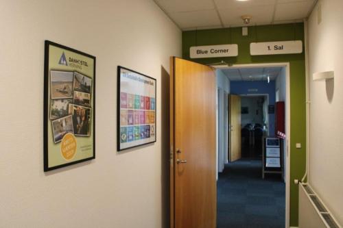 a hallway in a hospital with posters on the walls at Hostel Herning in Herning