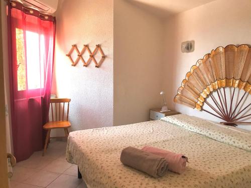 een slaapkamer met een groot bed met een houten hoofdeinde bij villette ginestre alte in Costa Rei