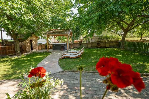 a garden with a bench and a gazebo at Provence Birtok in Decs