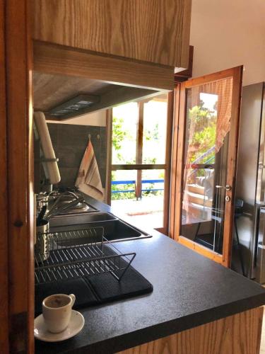 a kitchen with a cup of coffee on a counter at Elesta in Vourvourou