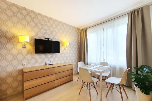 カリーニングラードにあるARS apartments Апартаменты на Арсенальнойの壁にテーブルとテレビが備わる部屋
