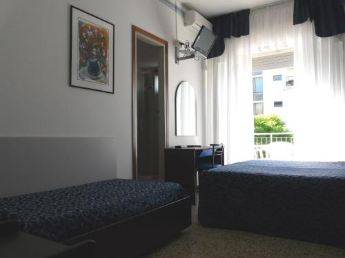 una camera d'albergo con due letti e una finestra di Hotel Altea a Lido di Jesolo