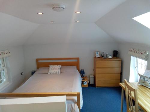 a bedroom with a bed and a dresser in a room at The Hayloft in Hornsea