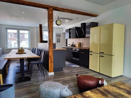 a kitchen with a table and a yellow refrigerator at Tolles schönes Ferienhaus mit großer Grillterrasse für 12 Personen im Harz in Sankt Andreasberg