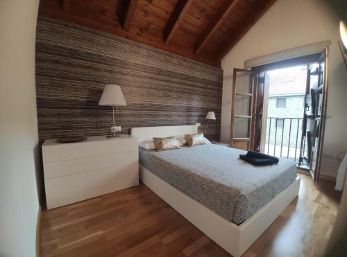 1 dormitorio con cama y ventana grande en Casa Orbil, en Villanúa