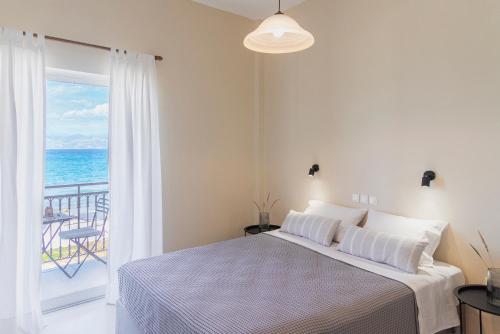 a bedroom with a bed and a view of the ocean at Kamini Apartments in Kavos