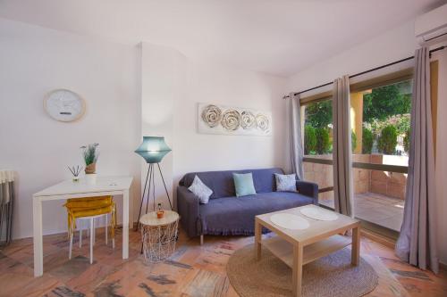 sala de estar con sofá azul y mesa en Romana Playa Elviria, en Marbella
