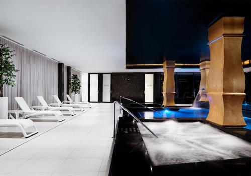a lobby with white chairs and a glass table at Dune Beach Resort in Mielno