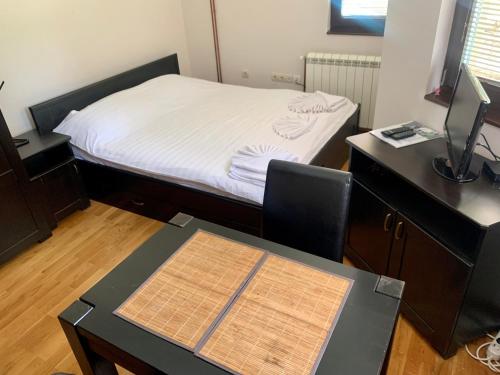 een slaapkamer met een bed en een bureau met een bureau bij Vila Darija Zlatar - studio apartman br. 2 in Nova Varoš