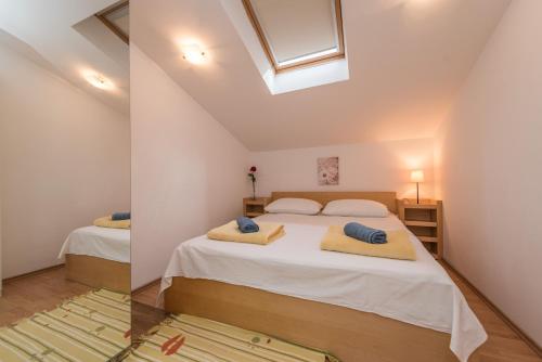 ein Schlafzimmer mit zwei Betten und einem Dachfenster in der Unterkunft Ilia sea view apartment in Novalja