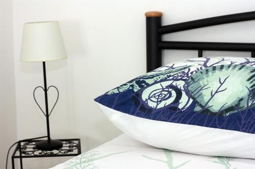 a bed with a blue and white pillow and a lamp at Apartment Zorica in Supetar