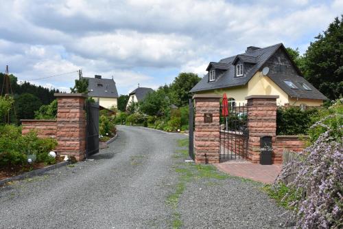une maison avec un portail en briques et une allée dans l'établissement Falkennest, à Dhronecken