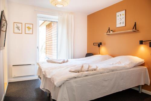 Schlafzimmer mit einem großen weißen Bett und einem Fenster in der Unterkunft Feriebyens Bed & Breakfast in Rødvig