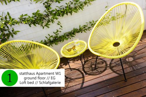 3 sedie gialle sedute su una terrazza di legno di statthaus - statt hotel a Colonia