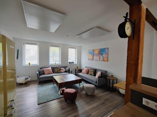 a living room with a couch and a table at Tolles schönes Ferienhaus mit großer Grillterrasse für 12 Personen im Harz in Sankt Andreasberg