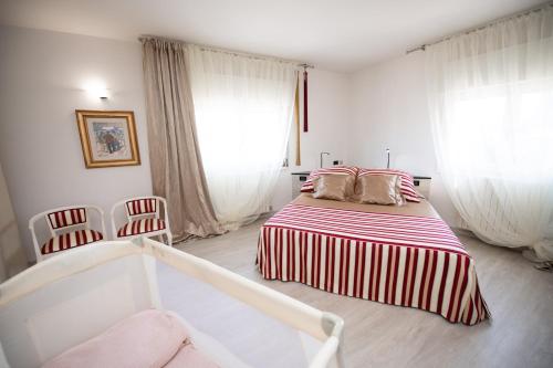 Habitación blanca con 1 cama y 2 sillas en Il Cortiletto - Appartamento Lores, en Manerba del Garda