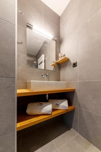 une salle de bain avec un lavabo et un miroir dans l'établissement AUBERGE DES GLIERES Plateau des Glières, à Thorens-Glières