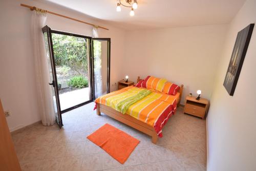 - une chambre avec un lit et une porte coulissante en verre dans l'établissement Igalo Garden Apartment, à Herceg-Novi