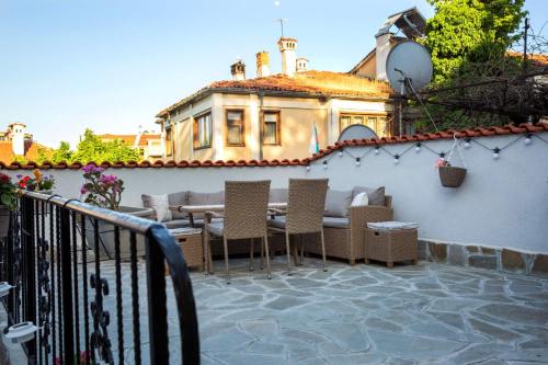 a patio with a table and chairs and a building at Old Town Plovdiv House Стаи за гости Марчеви - Стария град Пловдив in Plovdiv