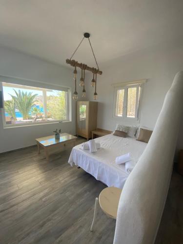 a bedroom with a white bed and a table at Only yours , Mykonos in Paraga