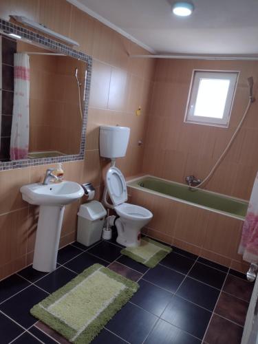 La salle de bains est pourvue de toilettes, d'un lavabo et d'une baignoire. dans l'établissement Ćane Rooms, à Bela Crkva