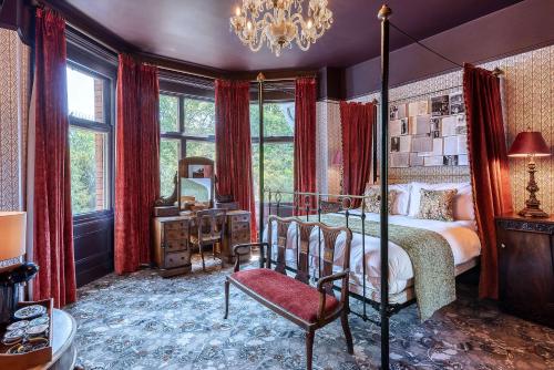 a bedroom with a bed and a chair and a chandelier at Clementine's Guest House in York