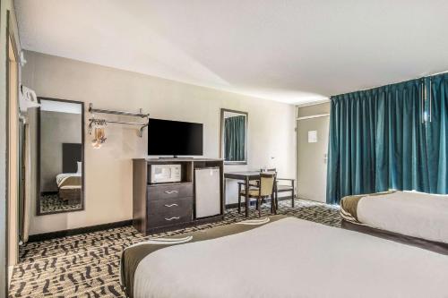 a hotel room with two beds and a flat screen tv at Quality Inn & Suites York East in York