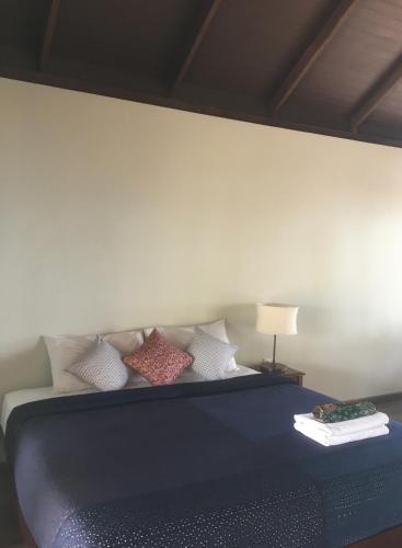 a bedroom with a blue bed with pillows at Jasmine & Tea House in Mae Nam