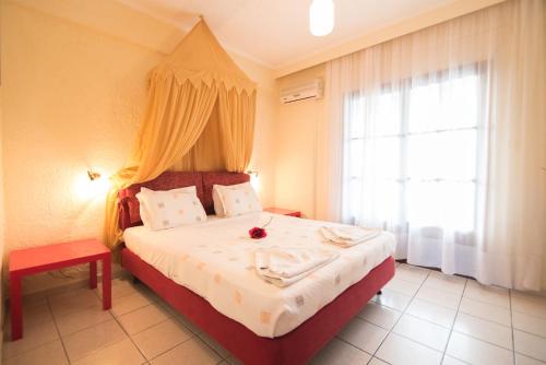 a bedroom with a large bed and a window at Villa Flegos in Skala Fourkas