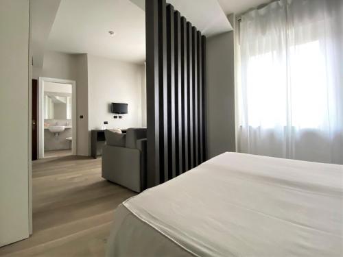 a bedroom with a bed and a couch and a television at Hotel Tirreno in Spotorno
