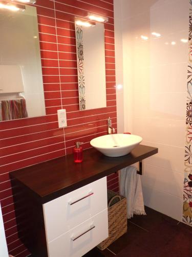 une salle de bain avec un lavabo et un miroir dans l'établissement Gîte Les Vignes, à Cravencères