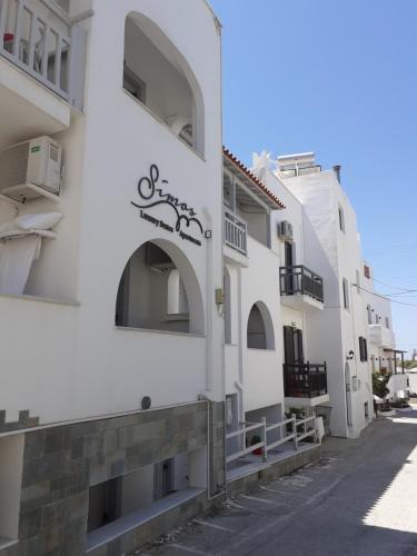 a white building with a sign on the side of it at simos luxury apartments in Naxos Chora