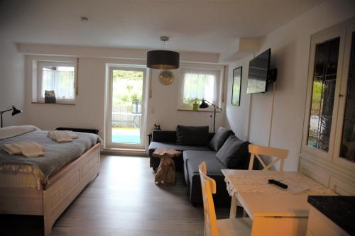 a living room with a couch and a bed at Hinterzarten Windeckweg by Kuckucksnester in Hinterzarten