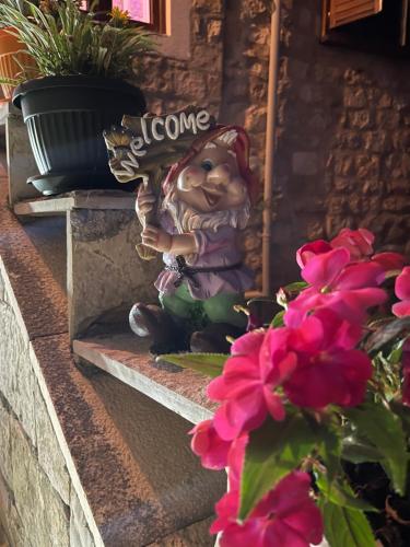 een klein beeldje zittend op een trap naast bloemen bij Guest House Alea in Ulcinj